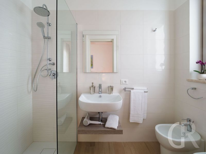 villa-pietra-del-sole-weisses-bad-mit-dusche-und-waschbecken.jpg