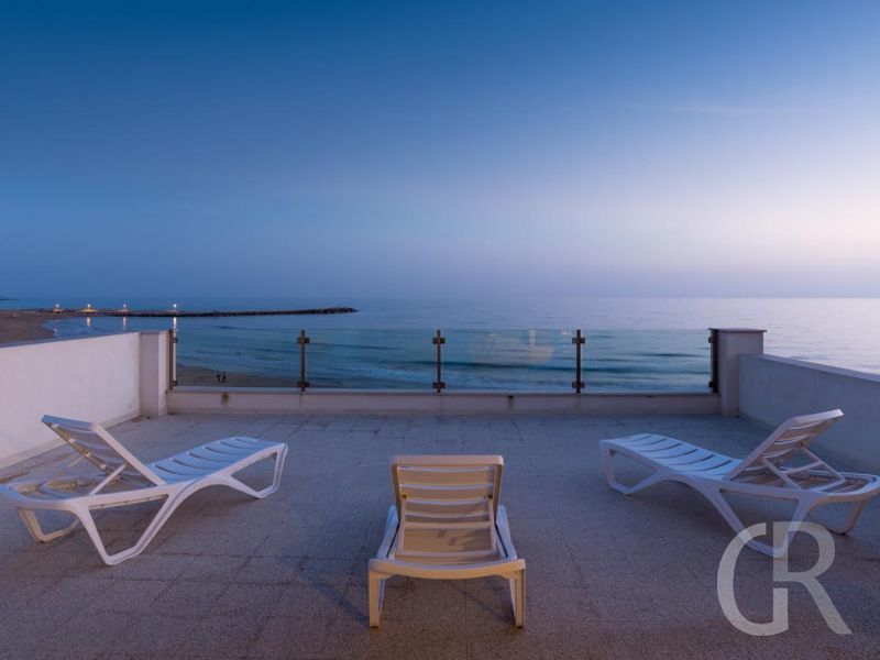 ferienwohnung-pitagora-terrasse-mit-sonnenliegen-bei-daemmerung.jpg