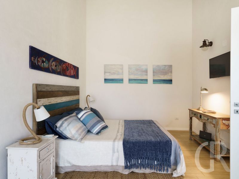 ferienhaus-marinella-blau-weisses-bett.jpg