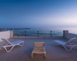 ferienwohnung-pitagora-terrasse-mit-sonnenliegen-bei-daemmerung.jpg