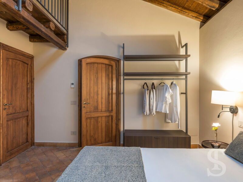 villa-continella-seitliche-ansicht-schlafzimmer-mit-holzdecken-und-galerie.jpg